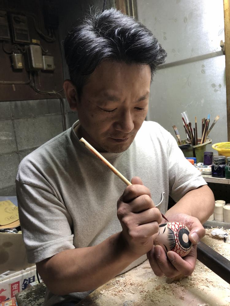 こけしに絵付けをしている阿部国敏さんの写真