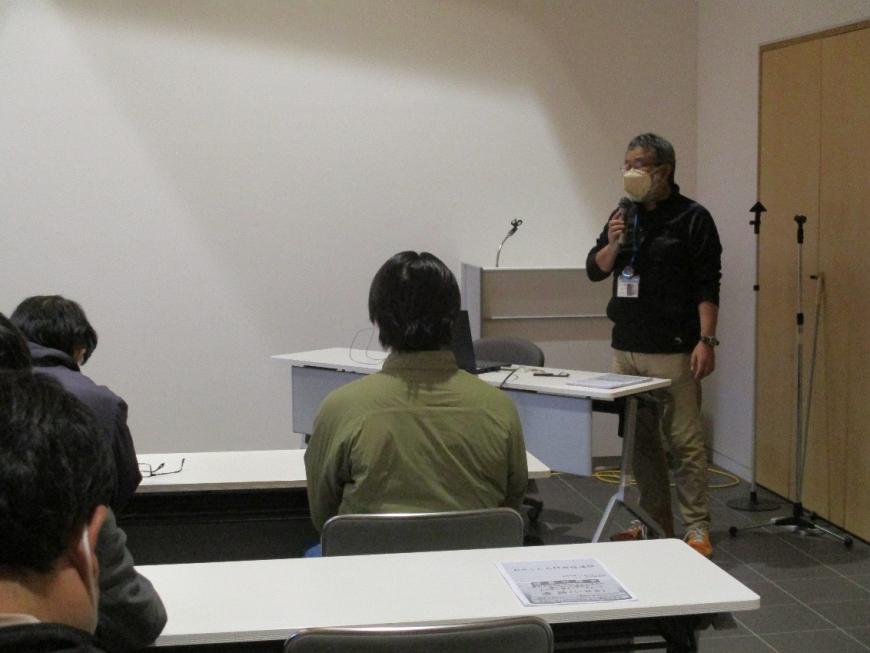 講演の前に受講者に話をする男性講師を撮影した写真