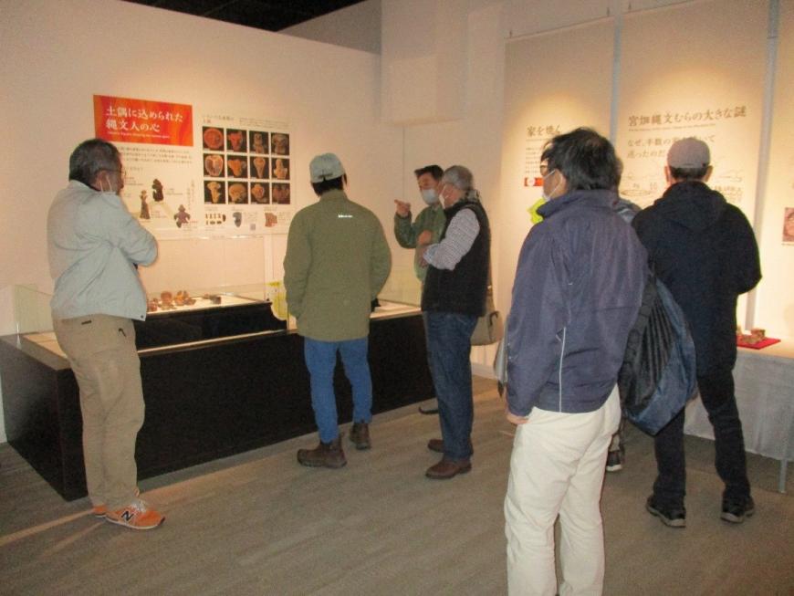 展示品を見ながら楽しそうに喋る受講者たちを撮影した写真