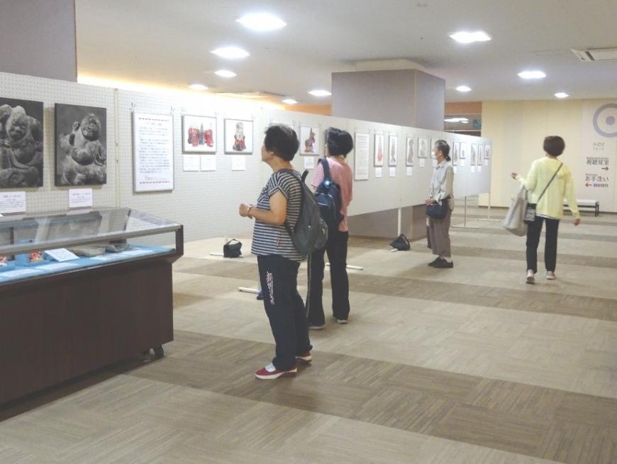 4名の方がパネルに展示された資料を見ている写真