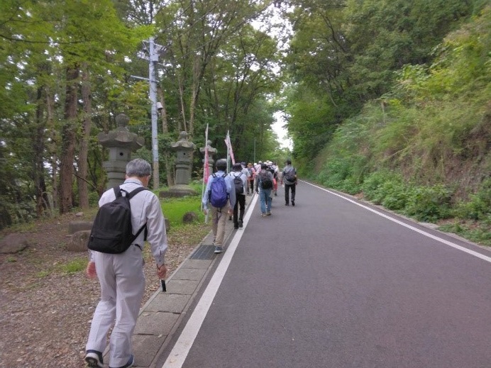 第一展望台に向かって道路を歩いていく受講者たちを後ろから撮影した写真