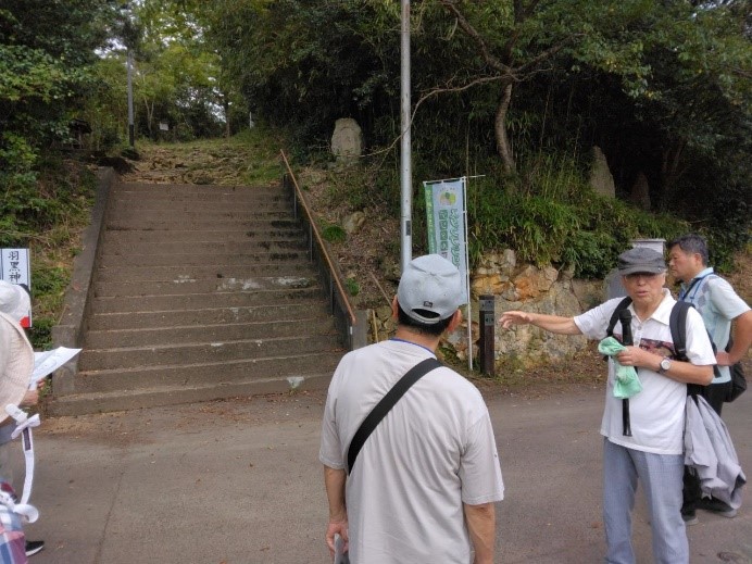 羽黒神社入口にある階段前で弘安の逆さ板碑について説明する講師を撮影した写真