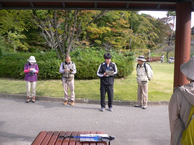 駒山公園で始まりの説明をしている講師を撮影した写真