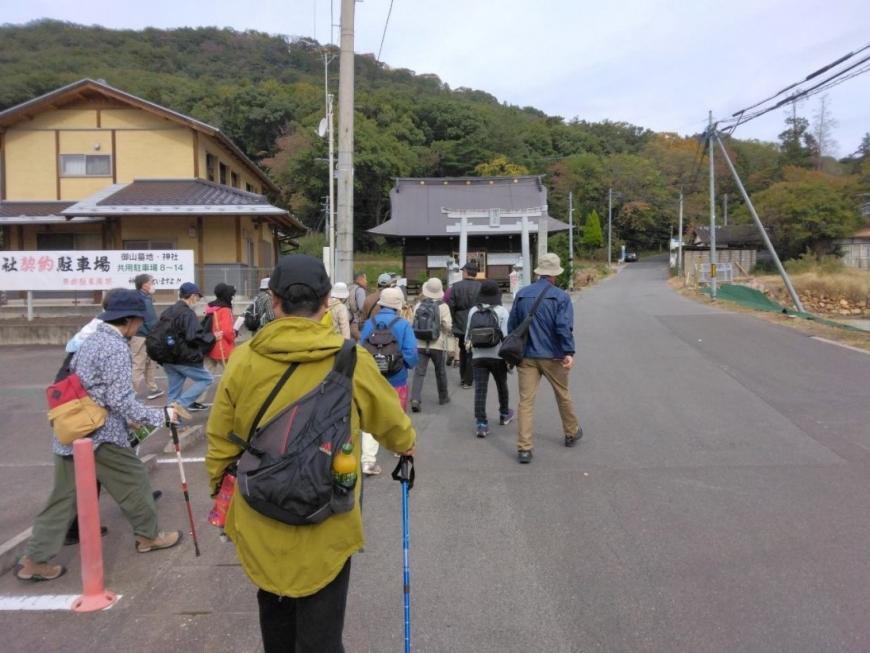 黒沼神社まで長く続く道路を歩いていく受講者たちを撮影した写真