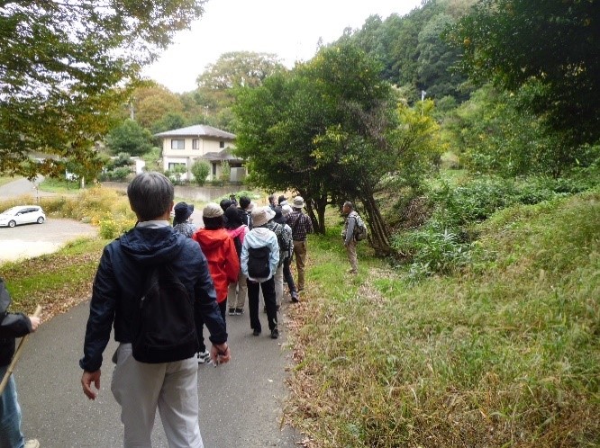 帰路にあるゆずの木を見ながら歩いていく講師と受講者たちを撮影した写真
