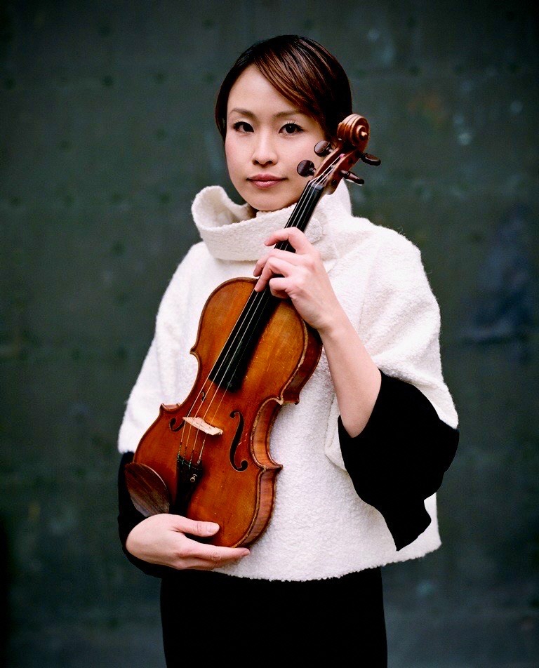 ヴァイオリンを持って写っているヴァイオリニスト田中さんの写真