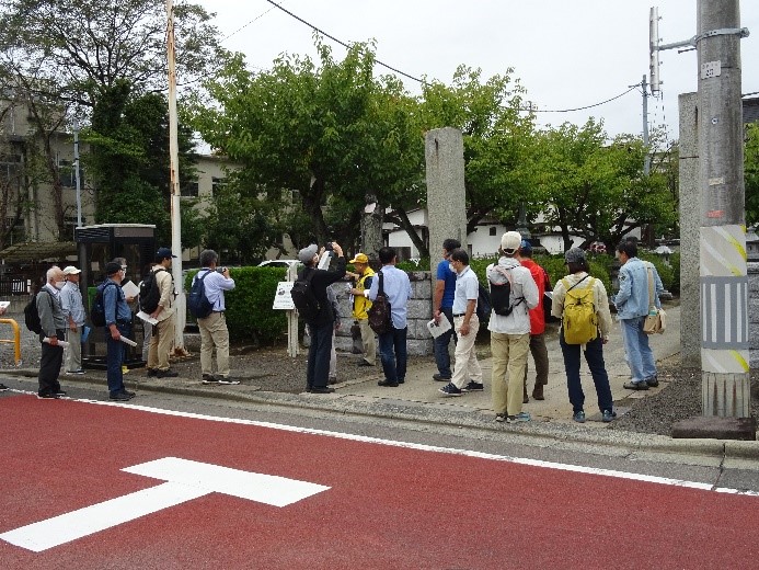 常光寺の入り口前で集まり説明をする講師の周りで話を聞く受講者たちの写真
