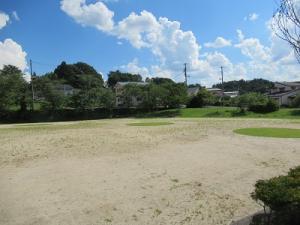 砂地の地面に円形に芝生が整備されている場所が2カ所ある飯野地区運動場の写真
