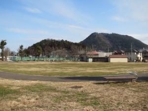 小高い山が見えている手前にある広々とした多目的広場を写した写真