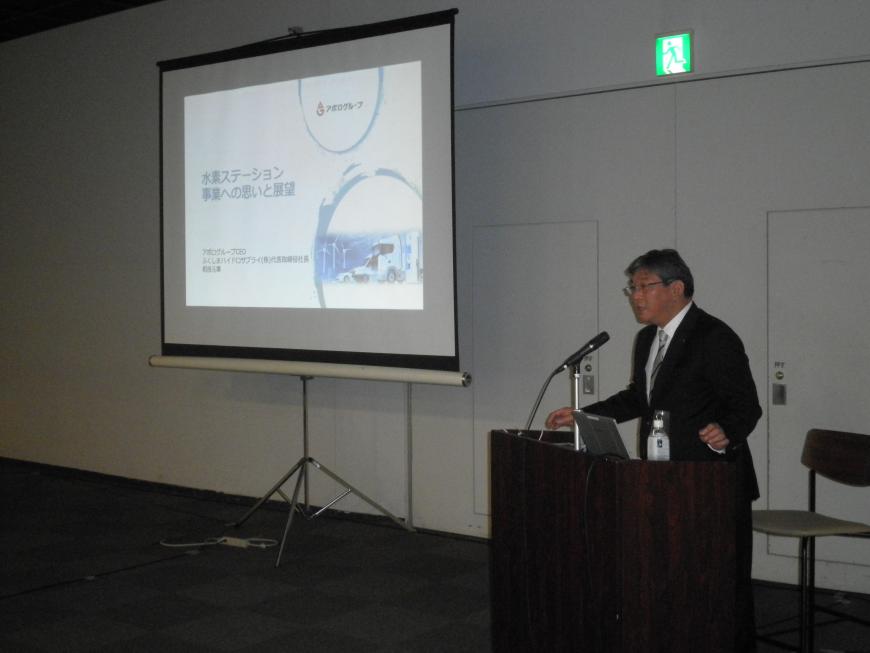 資料が投影されたスクリーンの横の演台に立って話をしている相良元章氏の写真