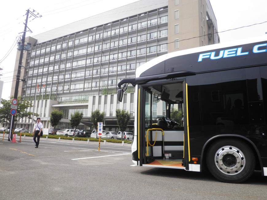 福島市役所の前の駐車場に停まっている黒い燃料電池バスの写真