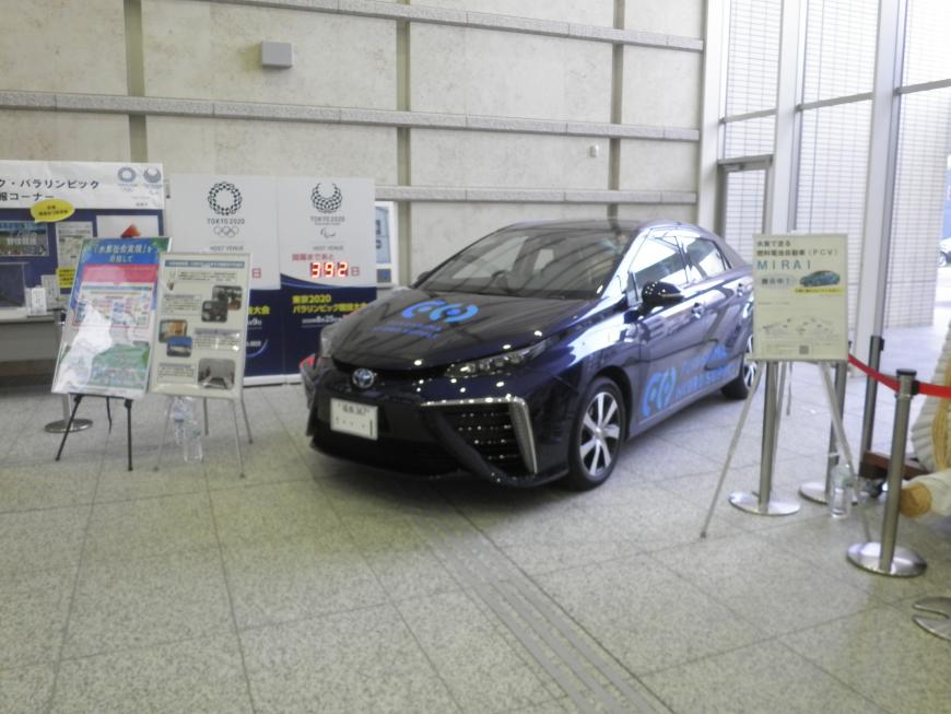 市役所のロビーに展示されている燃料電池自動車「ミライ」と横に置かれた説明パネルの写真
