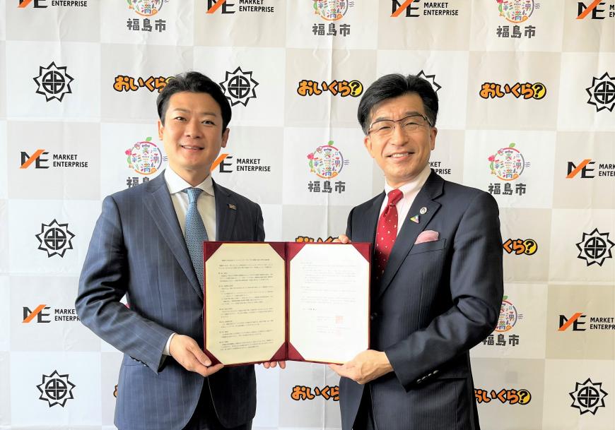 市長と男性が2人で協定書を持ちながら記念撮影をしている写真