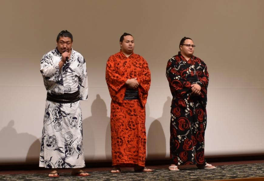 浴衣を着た福島市ゆかりの三力士がステージ上に立ち、左端に立っている力士がマイクを持ち話をしている写真