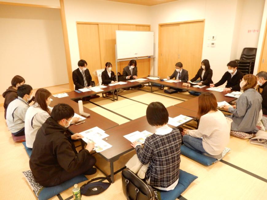 和室にロの字に設置された机に14名の関係者の方々が座り、話し合いが行われている写真