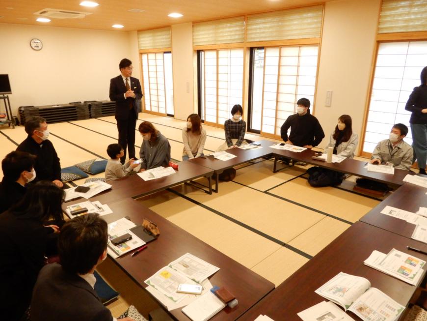 和室にロの字に設置された資料が並んだ机に関係者の方々が座り、立って話をする市長の話に耳を傾けている様子を写した写真