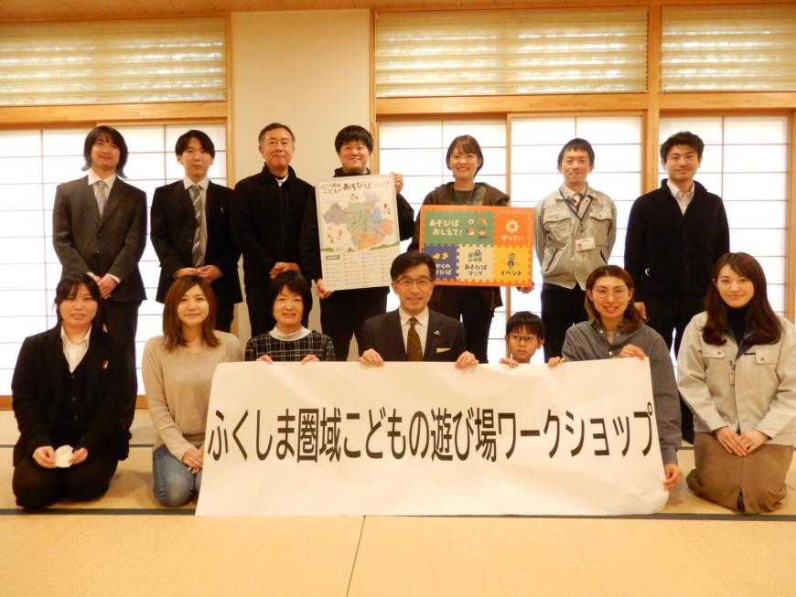 畳の上で市長と参加者の人たちが「ふくしま圏域こどもの遊び場ワークショップ」と書かれた横断幕を持ち記念撮影をしている写真