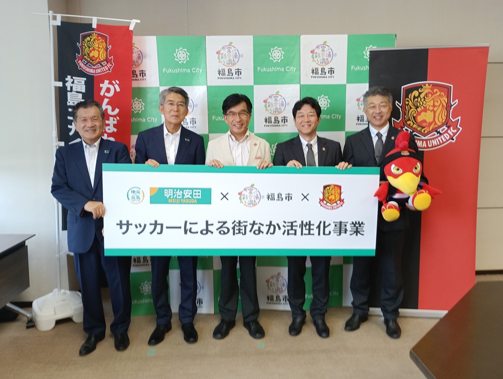 企業版ふるさと納税の感謝状贈呈の写真です。左に明治安田生命保険相互会社、中央に市長、右に福島ユナイテッドが写っています。
