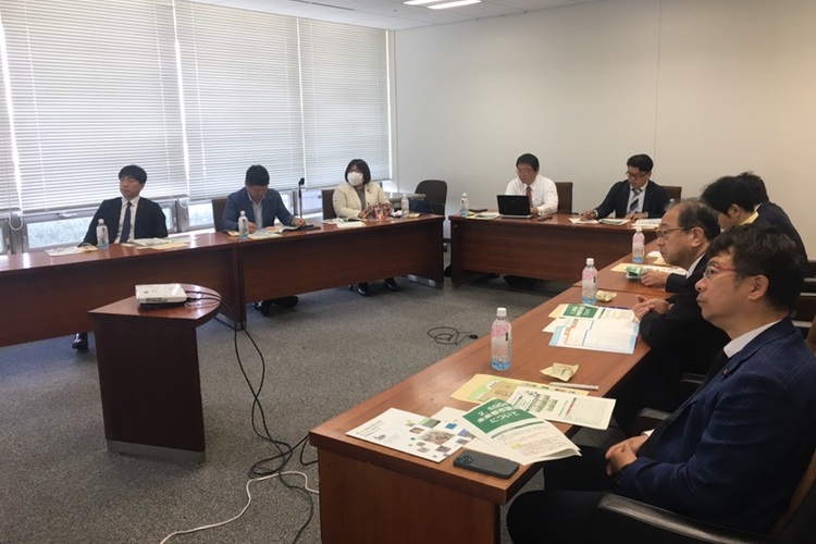 コの字型に設置された机に総務委員会の方々が座り説明を聞いている会議室内の写真