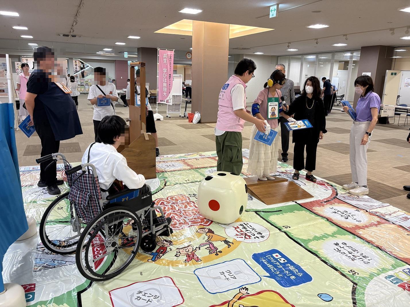 白内障の体験ゴーグルやイヤーマフをつけて、段差を渡ろうとする参加者をサポートする隊員