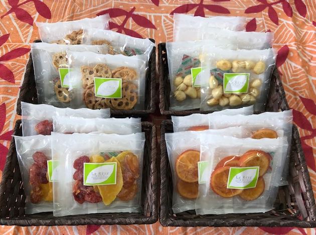 4つのカゴの中にそれぞれ4種類のドライフルーツや野菜スナックが置かれている写真