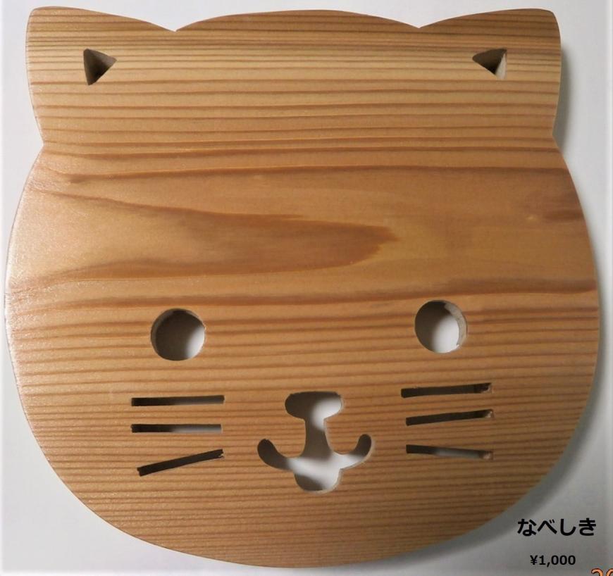 目鼻口や髭がくり抜かれた猫の顔をした木製の鍋敷きの写真