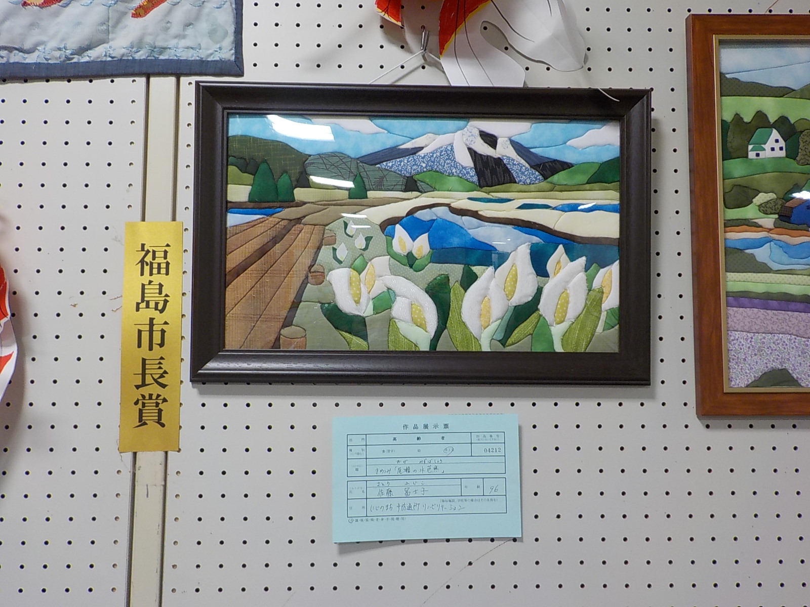 雪が積もった山の麓に咲く白い花の水芭蕉の風景を制作した福島市長賞受賞作品の写真