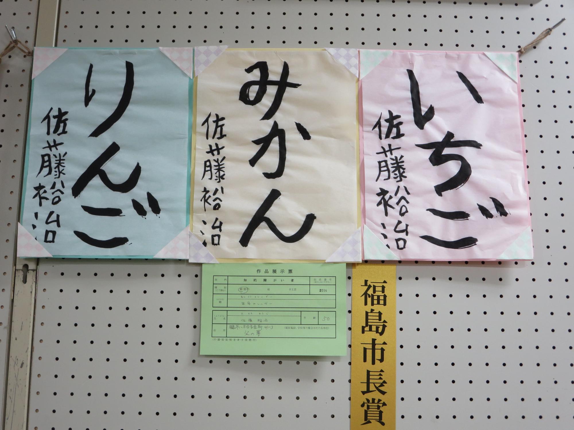ピンクや黄色に水色の紙にそれぞれ「いちご」「みかん」「りんご」の文字が書かれた福島市長賞受賞作品の写真