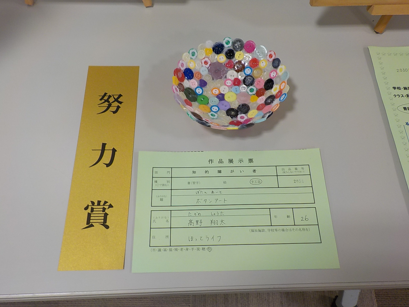 様々な形や色のボタンを半円形に繋げて作った努力賞受賞作品の写真