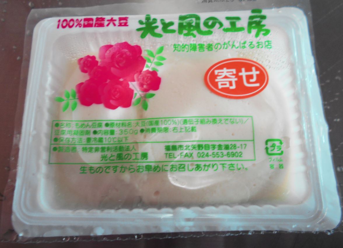 透明フィルムに「100%国産大豆 光と風の工房」と書かれた寄せ豆腐の写真