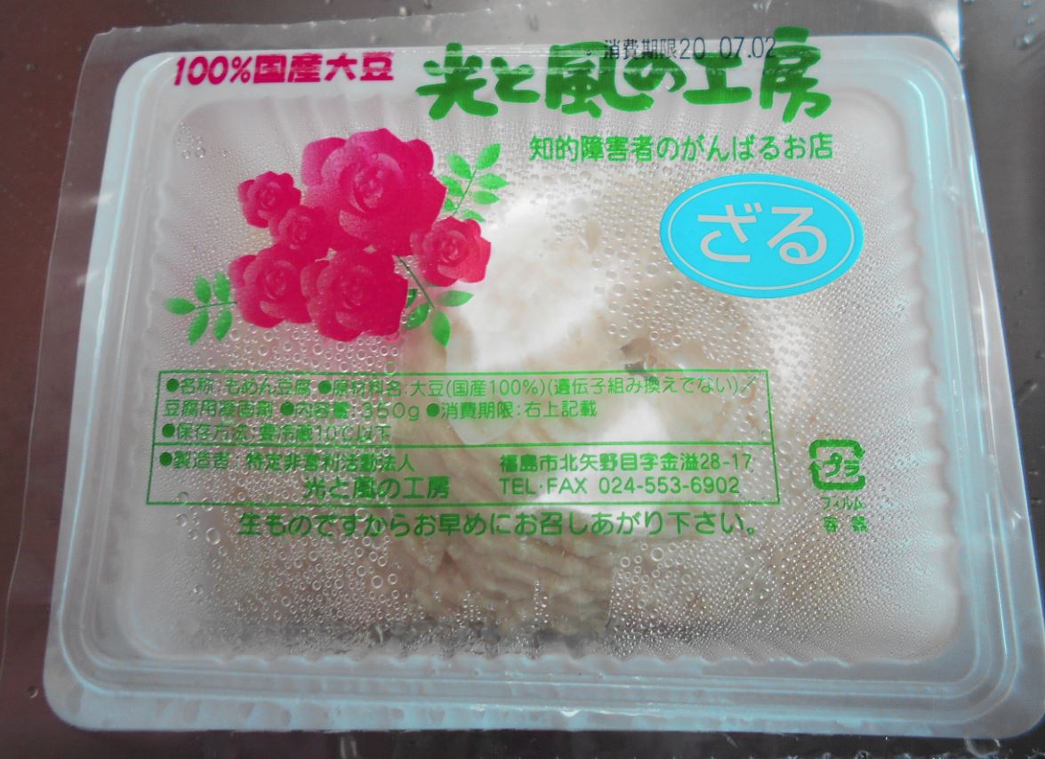 透明フィルムに「100%国産大豆 光と風の工房」と書かれたざる豆腐の写真