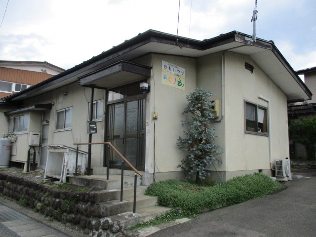ベージュ色の外壁に事業所名の「あとりえ」と書かれた看板が設置された建物外観の写真