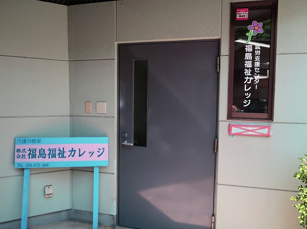 入り口ドアの傍に「福島福祉カレッジ」と書かれた看板が設置された写真