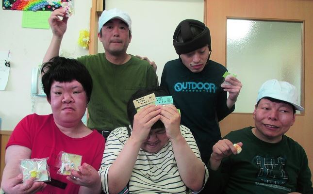 商品などをそれぞれ手に持った5人のおおぞらの夢の利用者の写真