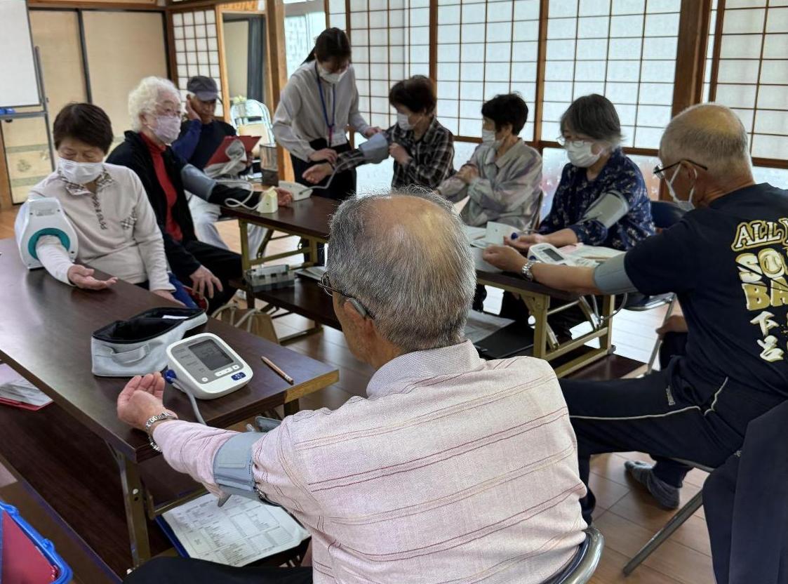 血圧計の正しい測り方を確認する参加者