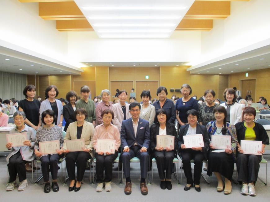 市長を中心にして横に並んだ椅子に感謝状を持った8人の女性が座り、その後ろに11人の女性が並んで立って写した感謝状贈呈者記念写真
