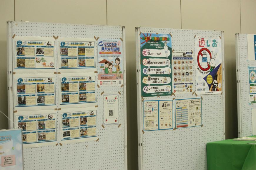 壁沿いに並んだ有孔ボードのパネルにポスターなどがたくさん展示されている写真