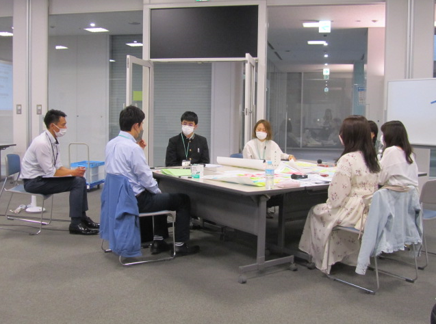 付箋に意見が書きだされ、7人が集まり話し合いが行われている写真