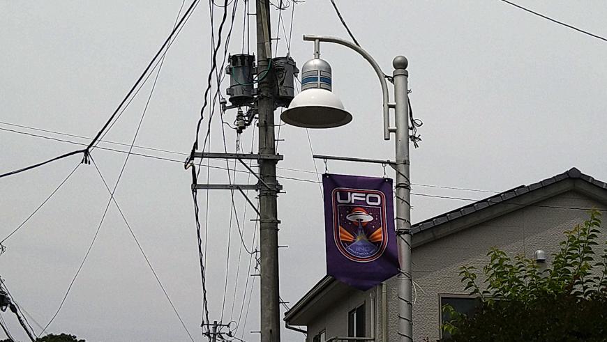UFO研究所のロゴ入りの旗が設置された街路灯の写真