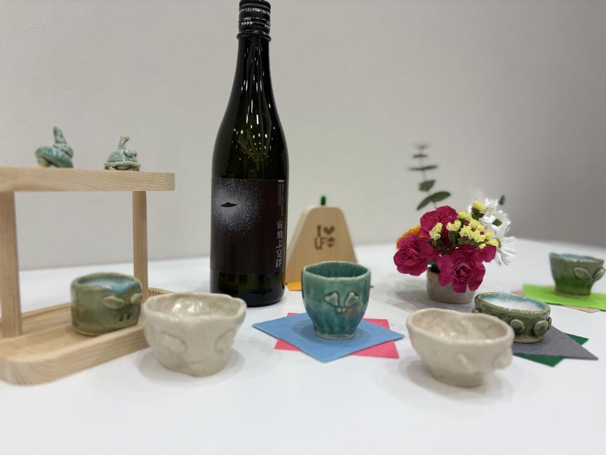 テーブルに新酒や陶器のコップが並べられた写真