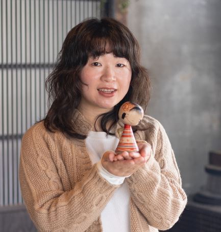 手の上にこけしを持った中風さんの写真