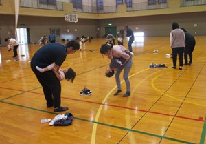 保護者の腰あたりに抱きついた子どもが手で支えてもらいながら仰向けに姿勢になっている写真