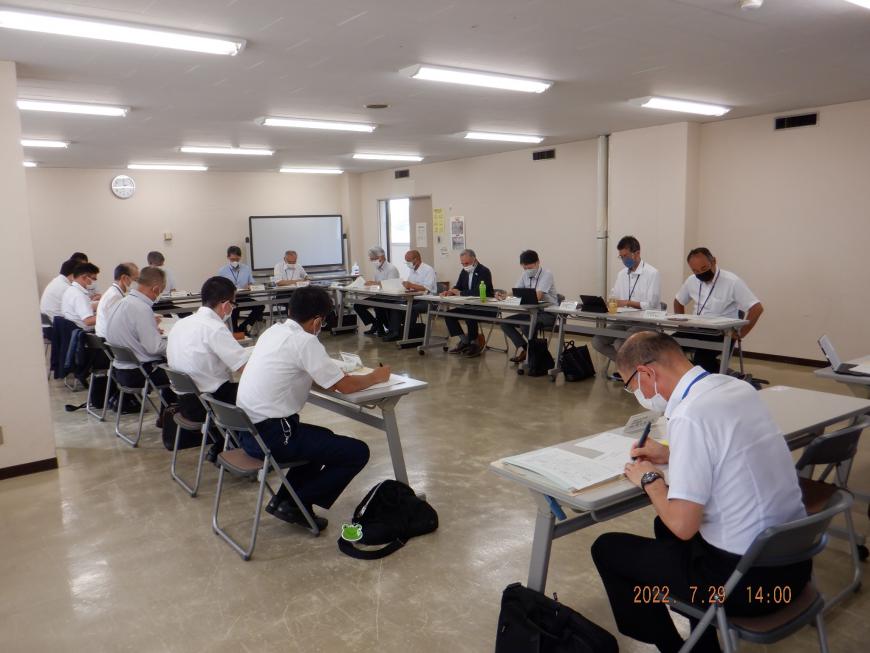 コの字型に設置された長机に関係者が座り会議が行われている様子の写真