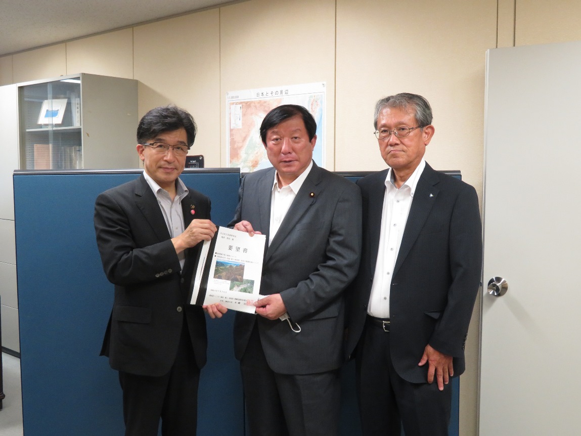 亀岡偉民副幹事長と福島市長が一緒に要望書を持ち3人の方が横一列に並び記念撮影をしている写真