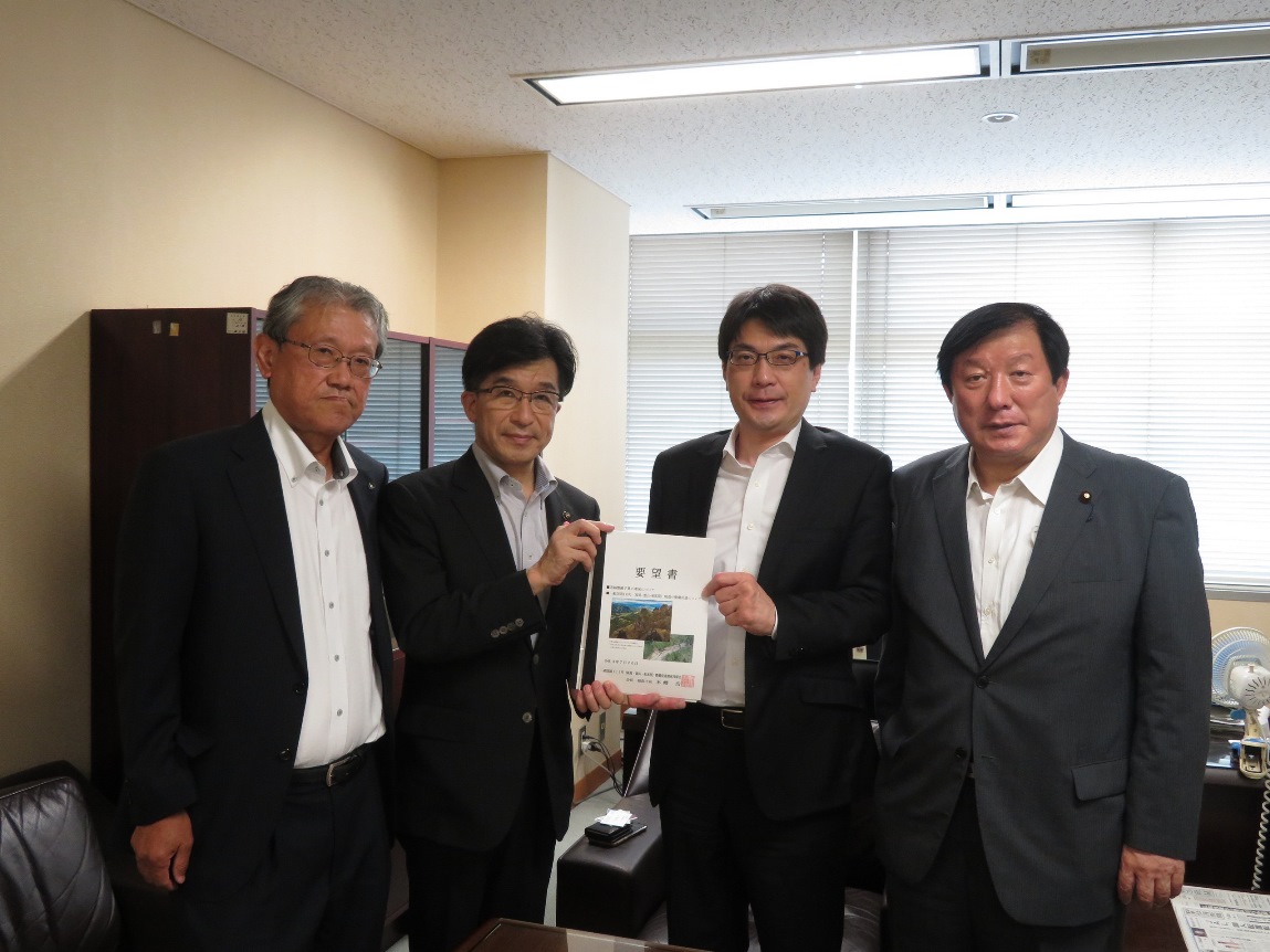 瓦林康人総合政策局長と福島市長を中心に要望書を持ち4人の方が横一列に並び記念撮影をしている写真