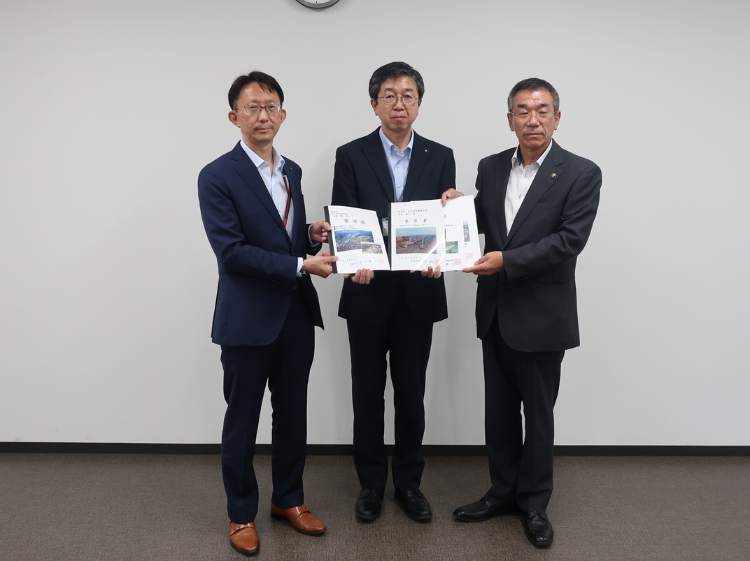 長嶺勝広県北建設事務所長を中心に3人の方が横一列に並び要望書を持ち記念撮影をしている写真