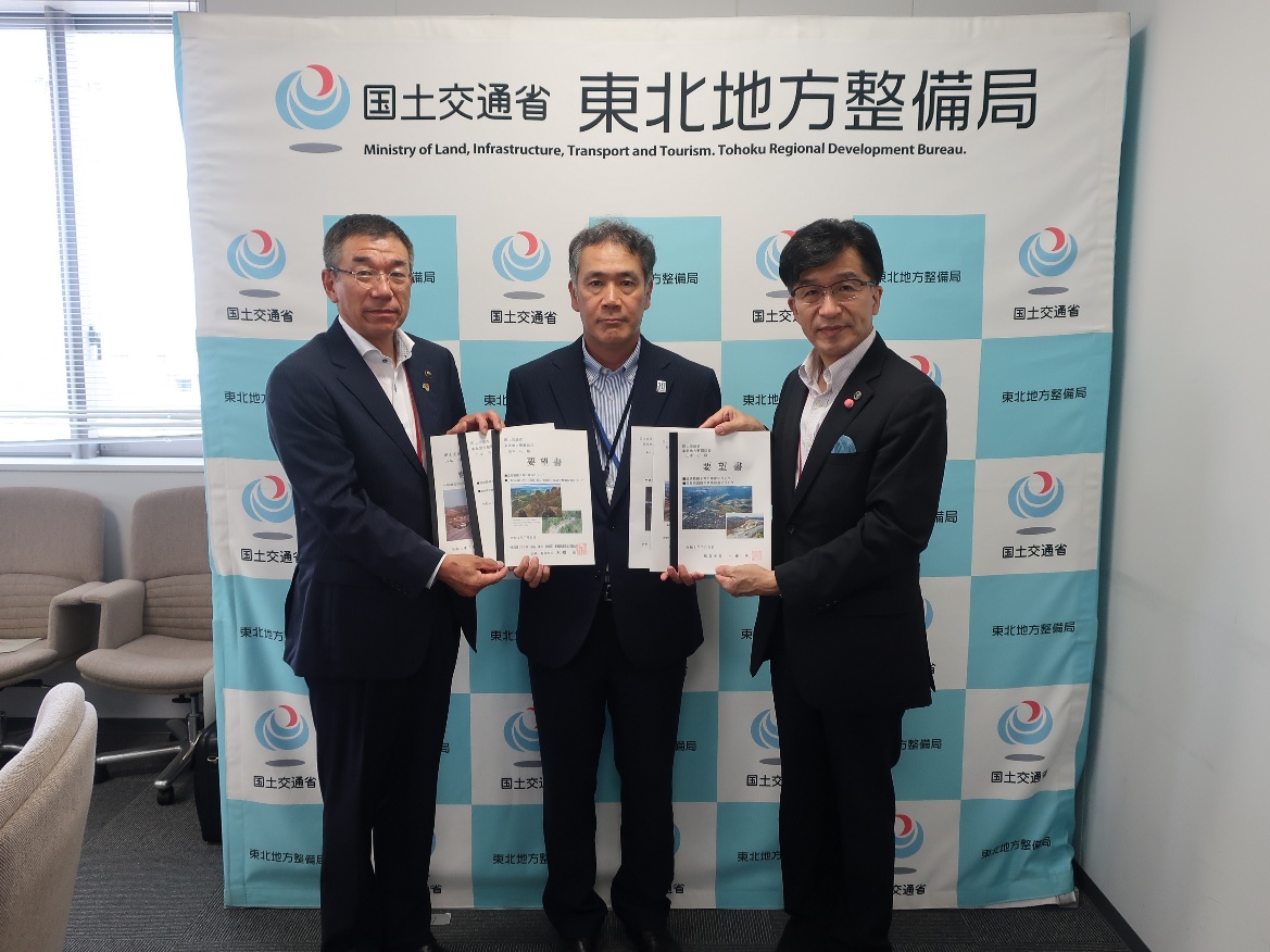 山本巧局長を中心に3人の方が横一列に並び要望書を持って記念撮影をしている写真