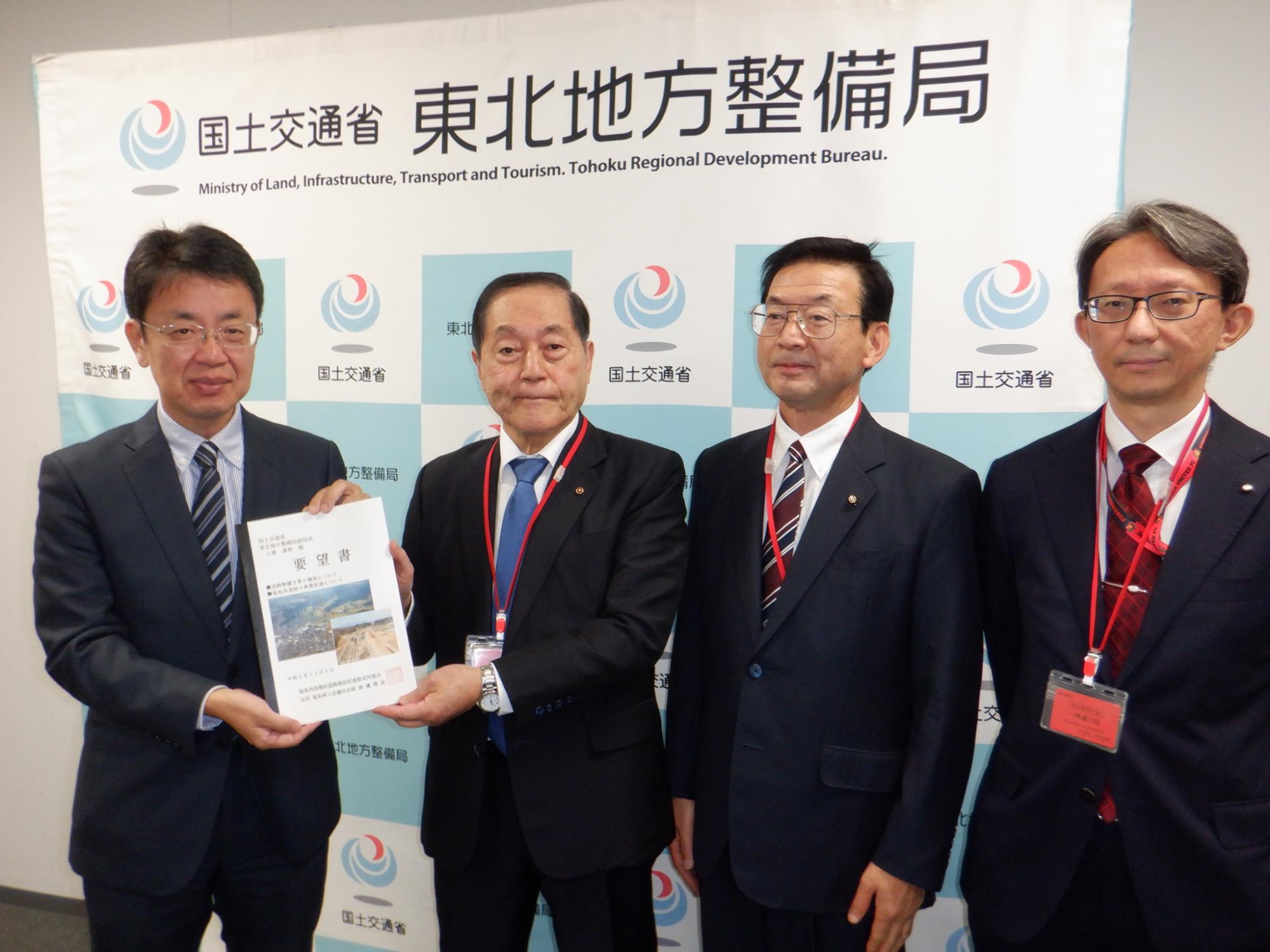 上森康幹副局長と渡邊博美福島商工会議所会頭が要望書を持ち4人の方が横一列になって記念撮影をしている写真