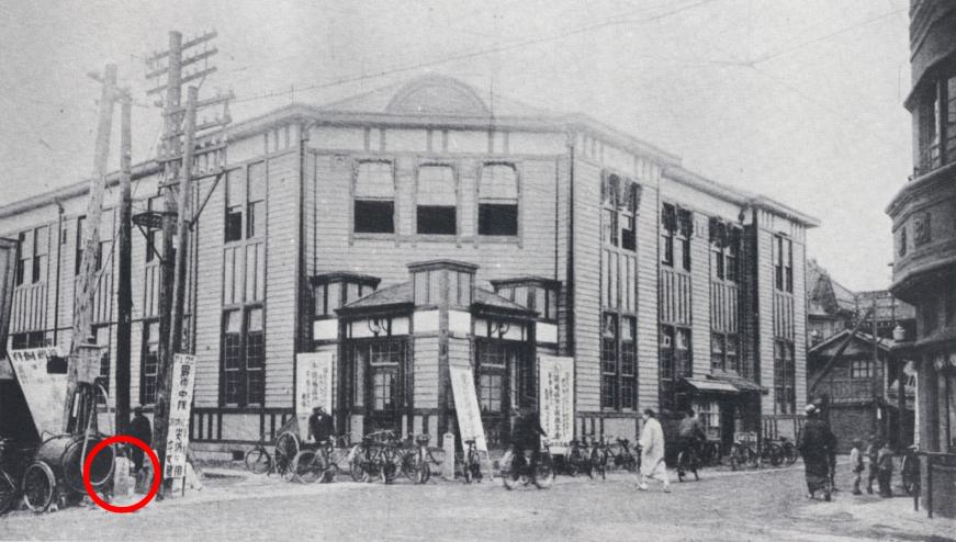 2階建ての洋風作りの福島郵便局を通りを挟んだ反対側に赤丸で印された「福島市道路元標」があるモノクロ写真