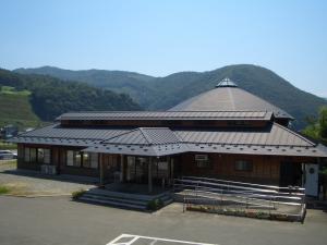 正面入り口へ続くスロープに手すりが設置され、外壁は木を基調とした瓦屋根のもにわの湯の外観